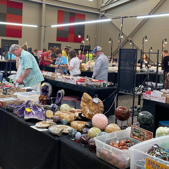 woman looking at gems and jewelry on tables
